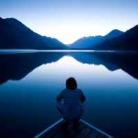 a persona sitting on the edge of a boat watching sea